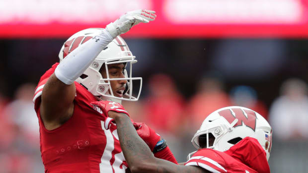 Wisconsin cornerback Max Lofy (No. 12) celebrates with a teammate after an interception versus Washington State